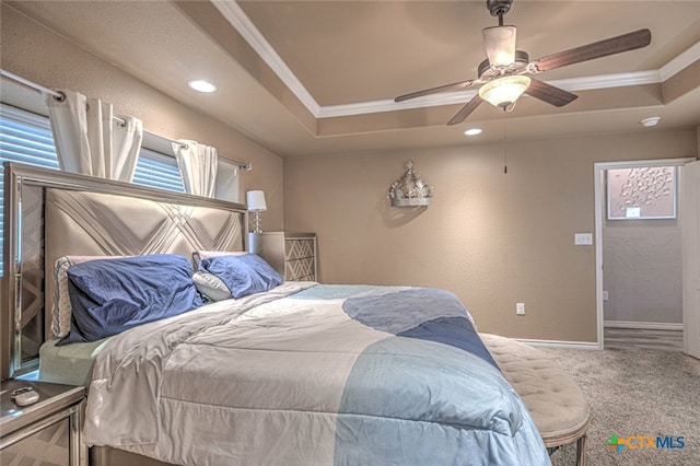 bedroom with a tray ceiling, carpet, ceiling fan, and crown molding