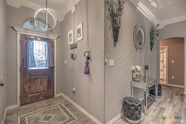 entryway with wood-type flooring and crown molding