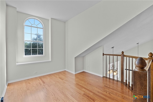 additional living space featuring baseboards and wood finished floors