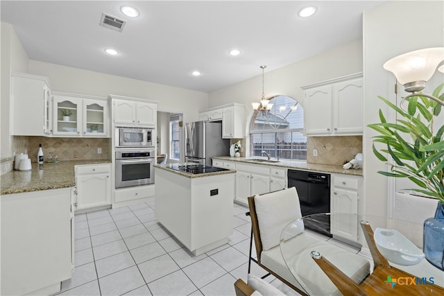 kitchen featuring visible vents, white cabinetry, light stone countertops, black appliances, and glass insert cabinets