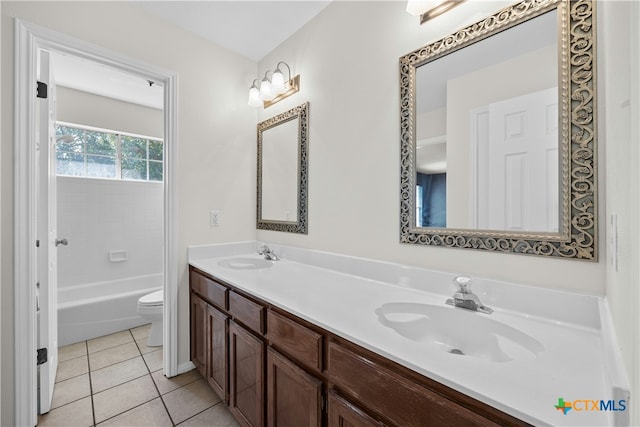 bathroom with double vanity, a sink, toilet, and tile patterned floors