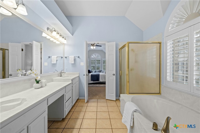 ensuite bathroom with a stall shower, tile patterned flooring, vaulted ceiling, and a sink