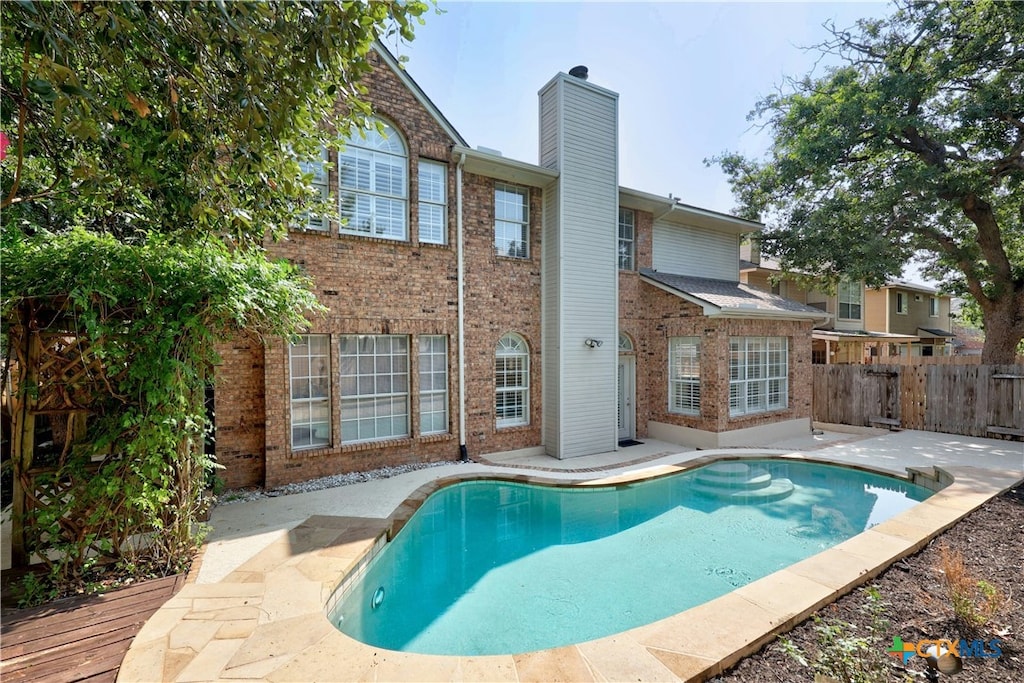 view of swimming pool featuring fence, a fenced in pool, and a patio