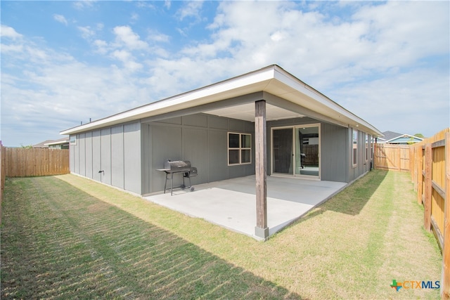 back of house with a patio and a yard