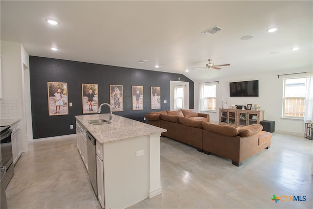 kitchen featuring plenty of natural light, white cabinetry, sink, and a kitchen island with sink