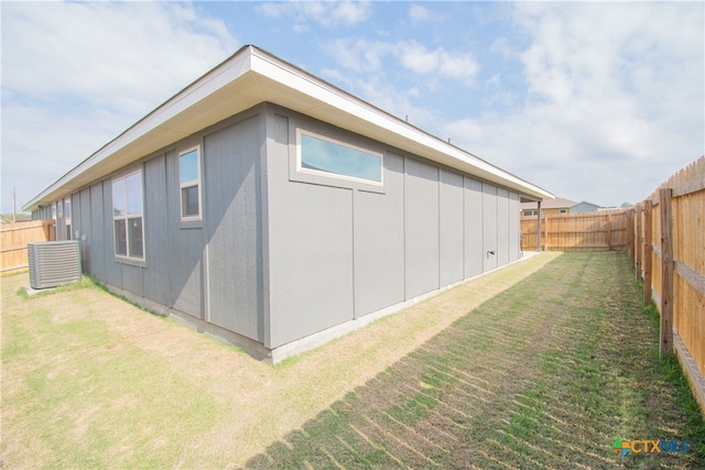 view of property exterior with central AC unit and a lawn