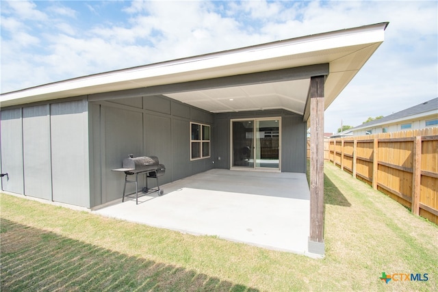 back of house with a patio area and a lawn