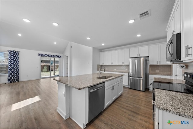 kitchen with a sink, white cabinetry, tasteful backsplash, stainless steel appliances, and visible vents