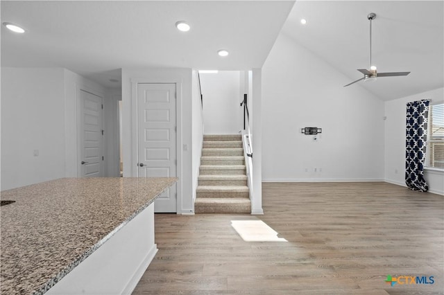 living room featuring stairway, lofted ceiling, light wood-style flooring, ceiling fan, and recessed lighting