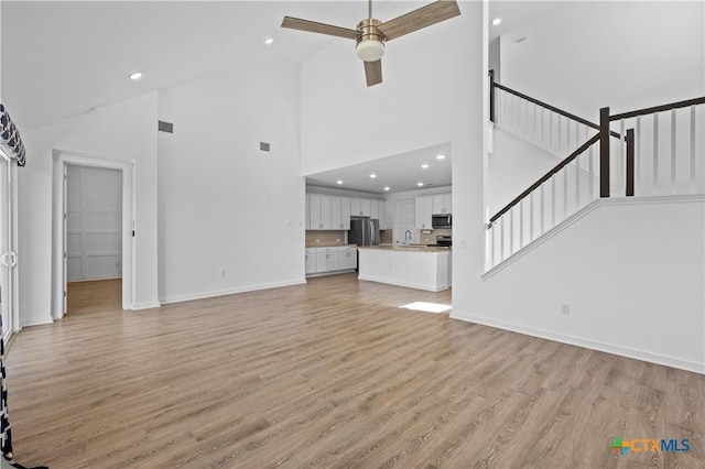 unfurnished living room featuring baseboards, light wood-style flooring, recessed lighting, and a ceiling fan