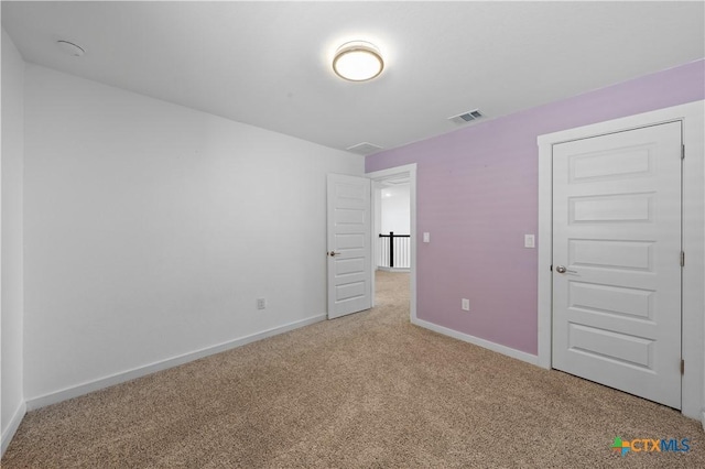 unfurnished bedroom featuring baseboards, carpet floors, and visible vents