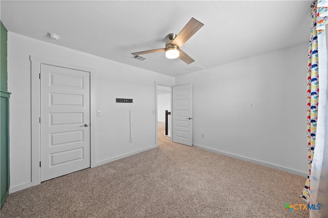 unfurnished bedroom featuring baseboards, a ceiling fan, visible vents, and carpet