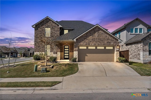 traditional-style home with driveway, stone siding, roof with shingles, brick siding, and a garage