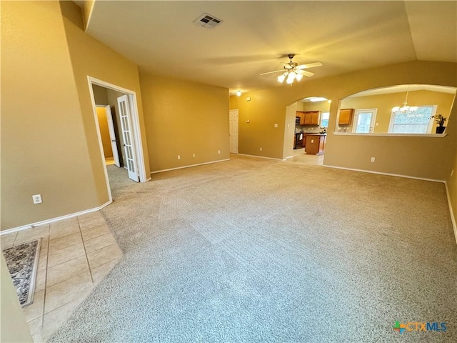 unfurnished living room with ceiling fan with notable chandelier and light tile patterned floors