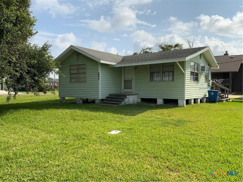 103 S Washington Ave, Port Oconnor, TX 77982 - rear view of house with a lawn and roof with shingles