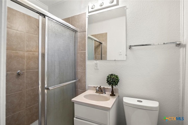 bathroom featuring vanity, toilet, and a shower with shower door