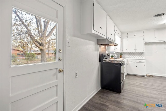 kitchen featuring black range with electric cooktop, white cabinetry, plenty of natural light, and backsplash