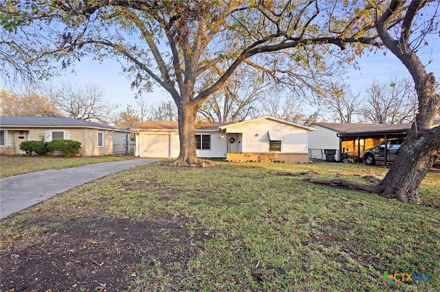 ranch-style home featuring a front yard, a garage, and a carport