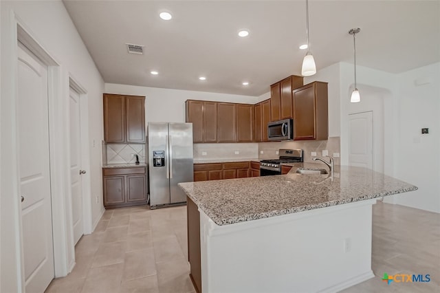 kitchen featuring sink, tasteful backsplash, decorative light fixtures, appliances with stainless steel finishes, and kitchen peninsula