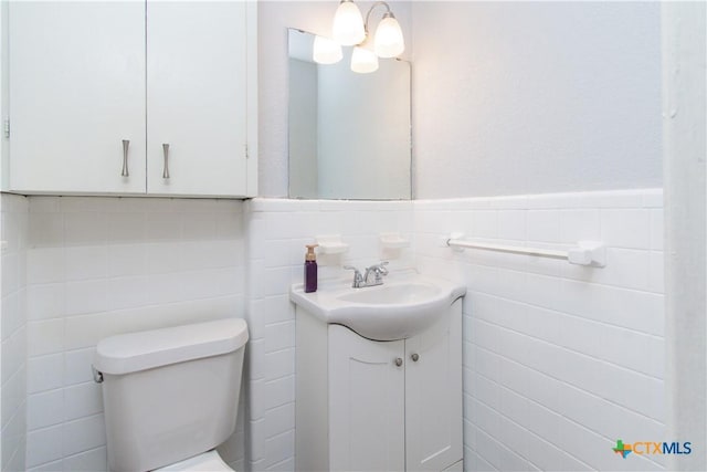 1902 S 41st St, Temple, TX 76504 - bathroom featuring tile walls, vanity, toilet, and a wainscoted wall