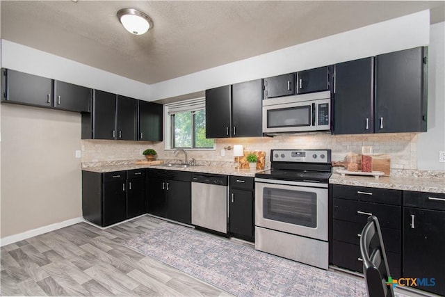 1902 S 41st St, Temple, TX 76504 - kitchen featuring appliances with stainless steel finishes, dark cabinets, a sink, and backsplash