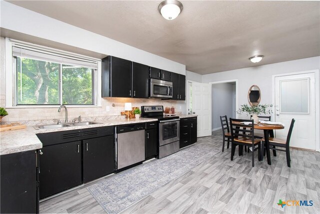 1902 S 41st St, Temple, TX 76504 - kitchen with stainless steel appliances, dark cabinets, a sink, light countertops, and decorative backsplash