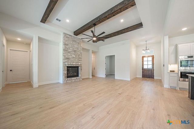 unfurnished living room with ceiling fan, a fireplace, beam ceiling, baseboards, and light wood-type flooring
