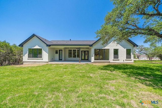 back of house featuring a patio, a yard, a ceiling fan, and stucco siding