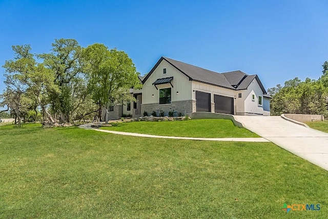 modern inspired farmhouse with stone siding, concrete driveway, a front yard, a garage, and board and batten siding