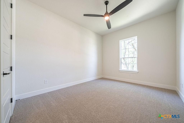 spare room featuring a ceiling fan, light carpet, and baseboards