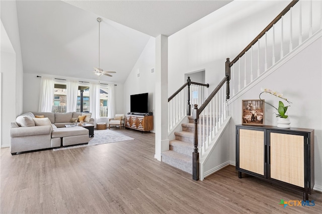427 Bluejack Way, Hutto, TX 78634 - living area featuring high vaulted ceiling, wood finished floors, stairway, ceiling fan, and baseboards
