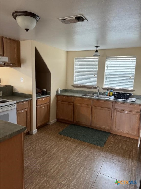 kitchen featuring a wealth of natural light, sink, and white electric range