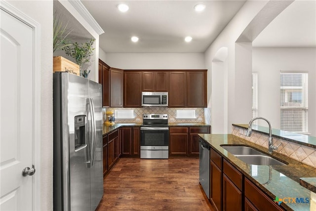 7805 Northgate Loop, Temple, TX 76502 - kitchen with appliances with stainless steel finishes, dark stone countertops, backsplash, dark wood-style flooring, and dark brown cabinetry
