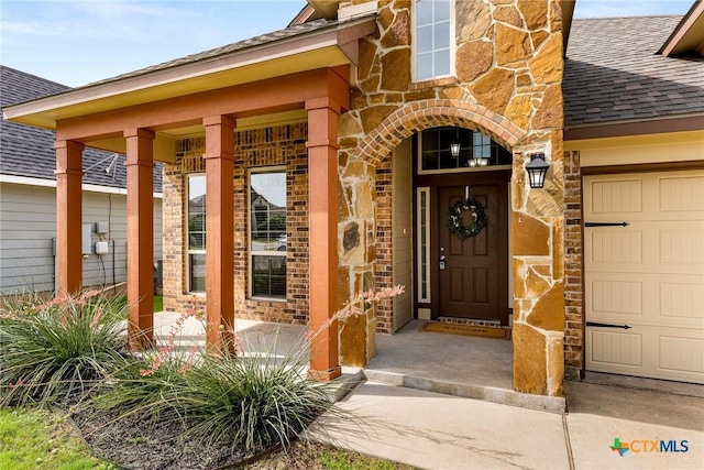 7805 Northgate Loop, Temple, TX 76502 - view of exterior entry featuring stone siding, roof with shingles, a garage, a porch, and brick siding