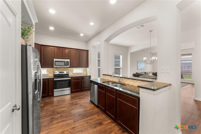 7805 Northgate Loop, Temple, TX 76502 - kitchen featuring stainless steel appliances, arched walkways, backsplash, dark wood-style floors, and plenty of natural light