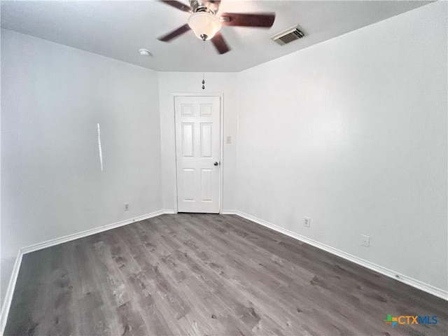 empty room with visible vents, baseboards, wood finished floors, and a ceiling fan