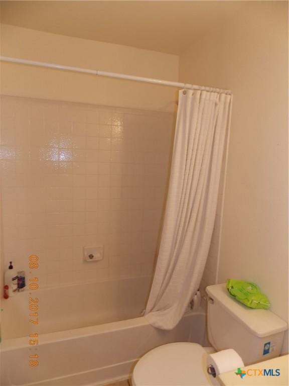 full bathroom featuring toilet and shower / bath combo with shower curtain