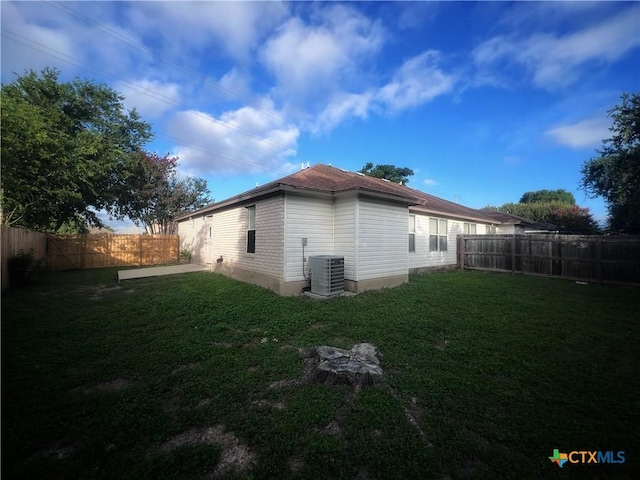 view of home's exterior with a yard, central AC unit, and a fenced backyard