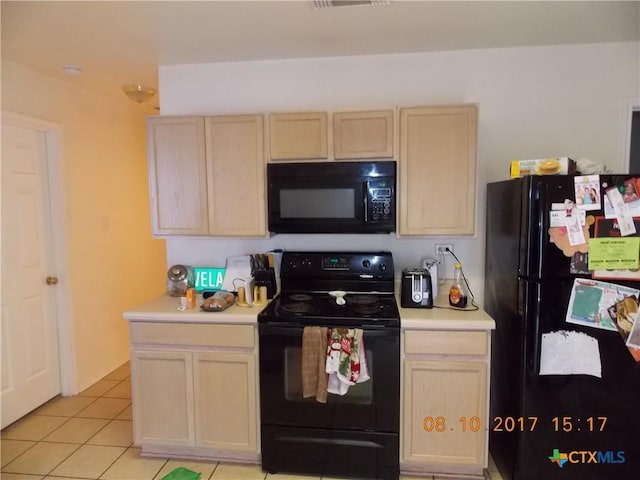 kitchen with visible vents, black appliances, light brown cabinets, light countertops, and light tile patterned floors