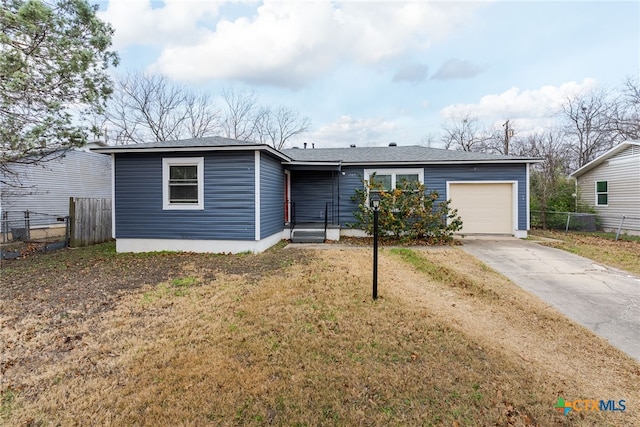 ranch-style home featuring a garage and a front lawn