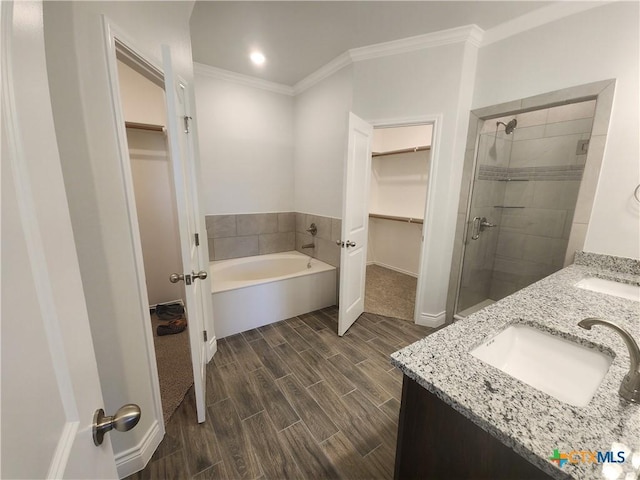6002 Monza Dr, Temple, TX 76502 - bathroom with a spacious closet, wood finish floors, a garden tub, a shower stall, and double vanity