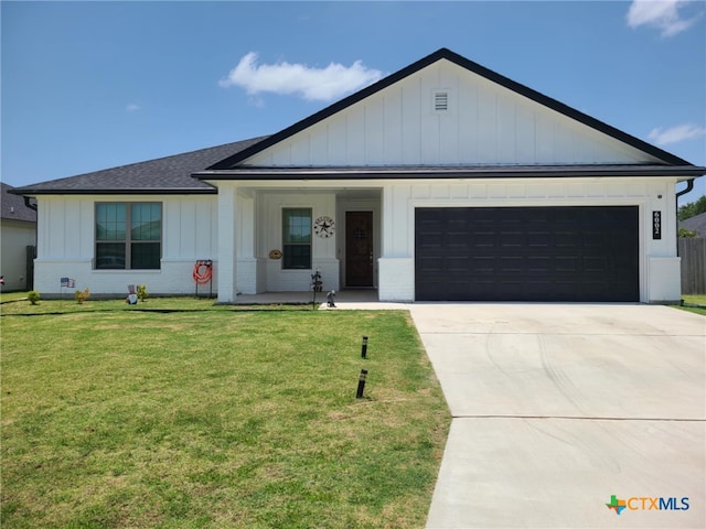 6002 Monza Dr, Temple, TX 76502 - view of front facade featuring board and batten siding, a garage, driveway, and a front yard