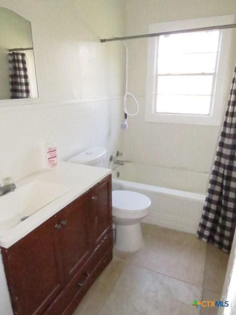 full bathroom featuring tile patterned floors, vanity, toilet, and shower / bath combo with shower curtain