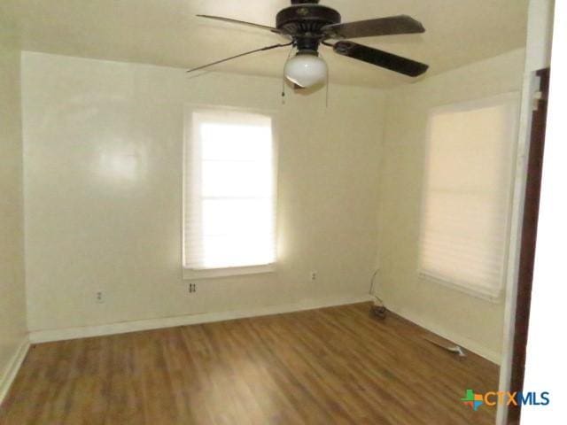 unfurnished room with ceiling fan and wood-type flooring