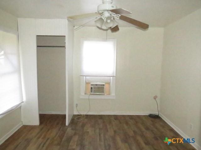 unfurnished bedroom with ceiling fan, cooling unit, and dark wood-type flooring