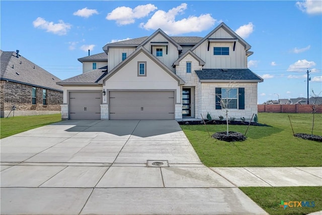 view of front of house featuring a front lawn, concrete driveway, board and batten siding, and roof with shingles