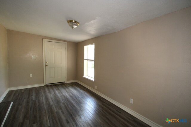 unfurnished room with dark hardwood / wood-style floors and vaulted ceiling