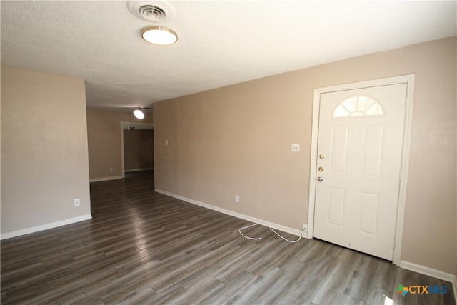 foyer with dark hardwood / wood-style flooring and a textured ceiling