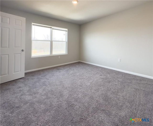 unfurnished room with baseboards and carpet floors