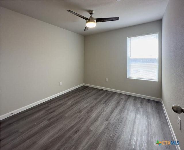 empty room featuring ceiling fan, baseboards, and dark wood-style floors